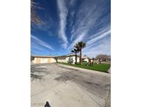 Single story home with a large front yard, palm trees, and desert landscaping at 5312 W Oakey Blvd, Las Vegas, NV 89146