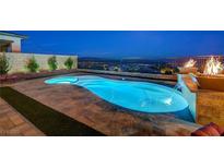 Enjoy this amazing pool with waterfall features and an elegant fire display overlooking the city lights at 8 Reverie Heights Ave, Henderson, NV 89011