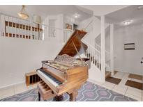 Inviting living area showcases a grand piano and staircase, perfect for entertaining guests at 8426 Sluman Ct, Las Vegas, NV 89128