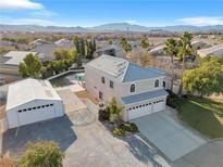 Stunning two-story home features an attached three-car garage, detached garage, and landscaped yard at 9435 Westwind Rd, Las Vegas, NV 89139