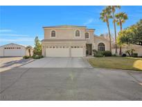 Charming two-story home featuring a spacious driveway, three-car garage, and well-manicured lawn, all under a clear blue sky at 9435 Westwind Rd, Las Vegas, NV 89139