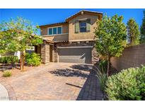 Charming two-story home with brick driveway, stone accents, lush trees, and a well-manicured lawn at 306 Dedication Ave, Henderson, NV 89011