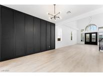 Open living room featuring modern lighting, sleek black accent wall, and light hardwood flooring at 9795 La Cienega St, Las Vegas, NV 89183