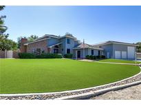 Two-story home with a well-maintained front lawn and a brick chimney on the left side of the building at 4075 E Oquendo Rd, Las Vegas, NV 89120