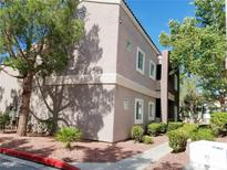 Tan two story apartment building with tidy landscaping, trees, and blue skies at 5250 S Rainbow Blvd # 1121, Las Vegas, NV 89118