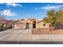 Charming single-story home with a three-car garage, desert landscaping, and a well-maintained lawn at 58 Desert Sunflower Cir, Henderson, NV 89002