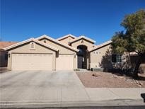 Charming single-story home with a two-car garage and desert landscaping under a bright blue sky at 58 Desert Sunflower Cir, Henderson, NV 89002