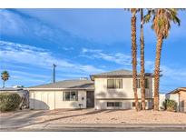 Bright, two-story home featuring desert landscaping and three mature palm trees in front at 6240 Clarice Ave, Las Vegas, NV 89107