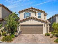 Two-story home featuring a neutral color scheme and a two-car garage, complemented by a well-maintained front yard at 9734 Cluny Ave, Las Vegas, NV 89178