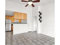 Open-concept living room features neutral tile flooring, ceiling fan, and combined kitchen at 3682 Melonies Dr # 5, Las Vegas, NV 89103