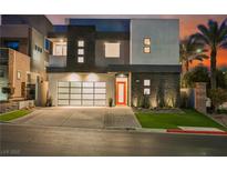 Modern two-story home with a glass garage door, orange front door, and drought-tolerant landscaping at 800 Loch Katrine Ave, Henderson, NV 89012