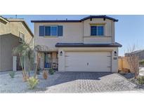 Inviting two-story home with a two-car garage, desert landscaping and charming curb appeal at 1631 Desert Path Ave, North Las Vegas, NV 89032