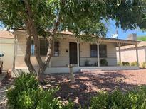 Charming single-story home with a covered front porch and mature shade trees in a well-kept yard at 239 N Bruce St, Las Vegas, NV 89101