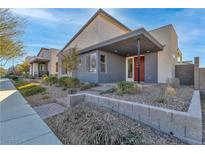 Stylish modern home with desert landscaping, covered entry, and gray and white exterior at 2494 Veronella St, Henderson, NV 89044