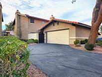 Charming home showcasing a two-car garage and well-manicured landscaping at 3999 Delos Dr, Las Vegas, NV 89103