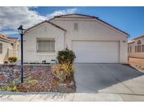 Charming single-story home with a two-car garage, desert landscaping, and mature bushes in a well-maintained neighborhood at 435 Regal Robin Way, North Las Vegas, NV 89084