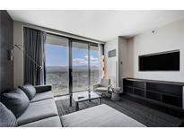 Modern living room with a plush couch, sleek furniture, and a stunning view from the large window at 4381 W Flamingo Rd # 3007, Las Vegas, NV 89103