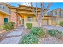 Charming home featuring a landscaped front yard, brick accents, and a welcoming front porch at 3049 Echoed Rondel Ln, Henderson, NV 89044
