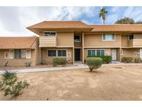 Two-story tan condo with a brown roof, small bushes, and decorative window covers at 2506 Paradise Village Way, Las Vegas, NV 89120