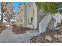 Condo exterior featuring stucco siding, staircase, and mature trees at 4404 W Lake Mead Blvd # 102, Las Vegas, NV 89108