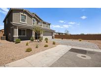 Charming two-story home featuring a desert landscape, gray paint scheme and a paved driveway at 70 Pikiariki Ct, Las Vegas, NV 89183
