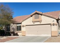 Home exterior featuring a two car garage with a tan door, stucco siding, and a terracotta tile roof at 7515 Splashing Rock Dr, Las Vegas, NV 89131