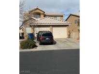 Two-story home featuring a two-car garage and neutral-toned exterior with some landscaping at 8012 Draco Cir # 101, Las Vegas, NV 89128