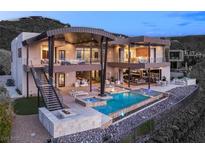 Contemporary home featuring a luxurious backyard with a pool, spa, and fire pit lounge area at 11 Rockstream Dr, Henderson, NV 89012