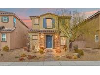Charming two-story home featuring stone accents, a tiled roof, and desert landscaping at 1141 Glistening Acres Ave, North Las Vegas, NV 89086