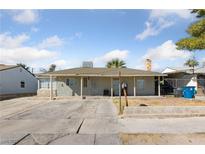 Single story home featuring covered porch and a spacious driveway under a bright sky at 214 Earl St, Las Vegas, NV 89101