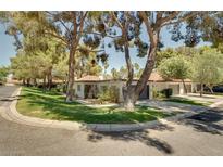 Charming single-story home featuring a tile roof, mature trees, and well-maintained landscaping at 2556 Palmera Cir, Las Vegas, NV 89121