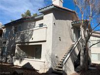 Two-story condo with stucco siding, staircase, and small balcony at 3119 Key Largo Dr # 204, Las Vegas, NV 89120