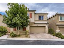 Two-story home with a two-car garage, desert landscaping, and a mature shade tree in the front yard at 7788 Ebro Valley Ct, Las Vegas, NV 89113