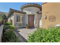 Charming front entrance with landscaped brick courtyard and inviting seating area with desert landscaping at 10057 Regency Canyon Way, Las Vegas, NV 89148