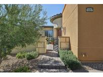 Inviting front entrance with a stone walkway, lush landscaping and charming curb appeal at 10057 Regency Canyon Way, Las Vegas, NV 89148