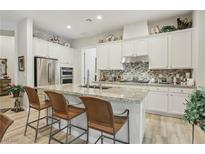 Bright kitchen with granite countertops, stainless steel appliances, and ample cabinet space at 10057 Regency Canyon Way, Las Vegas, NV 89148