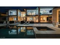 Stunning backyard with a modern pool, spa, lounge area, and outdoor spiral staircase, perfect for relaxation at 1704 Tangiers Dr, Henderson, NV 89012