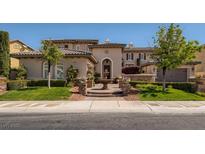 Elegant home featuring a well-manicured lawn, stone accents, and a charming fountain at 2038 Cherry Creek Cir, Las Vegas, NV 89135