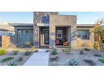 Charming single-story home with a stone accent wall and manicured desert landscaping at 905 Belleforte Ln, Las Vegas, NV 89138