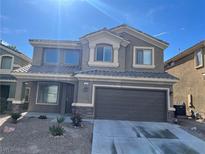 Two-story home with gray stucco, stone accents, desert landscaping, and a two-car garage at , Las Vegas, NV 89148