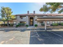 Exterior view of the condo featuring a terracotta tile roof, covered parking and desert landscaping at 2606 S Durango Dr # 232, Las Vegas, NV 89117