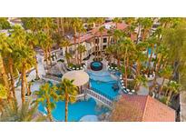Aerial view of a luxurious backyard featuring a stunning pool with a bridge, water slide, grotto and lush landscaping at 2818 E Quail Ave, Las Vegas, NV 89120