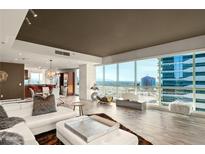 Bright living room with hardwood floors, modern decor, and a stunning city view through expansive windows at 4525 Dean Martin Dr # 2800, Las Vegas, NV 89103