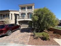 Charming two-story home featuring a paved driveway, a well-maintained lawn, and a two-car garage at 7068 Parrot Bay Way, Las Vegas, NV 89118