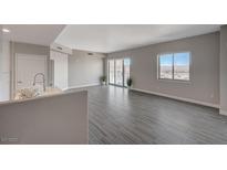 Bright open-concept living room with sliding glass doors and a large window overlooking the city and mountain view at 8255 S Las Vegas Blvd # 2004, Las Vegas, NV 89123