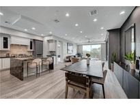 Open-concept living area featuring a kitchen with an island, dining area, and comfortable seating with a view at 9101 Alta Dr # 11, Las Vegas, NV 89145