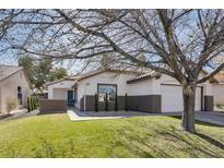 Charming single-story home featuring a well-manicured front yard with mature trees and an attached garage at 1323 Winter Solstice Ave, Henderson, NV 89014