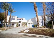 Striking white home featuring meticulous landscaping, palm trees, and a curved driveway at 2010 Mondo Ct, Las Vegas, NV 89123