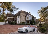 Stunning Tudor-style home with brick chimney and a well-manicured front yard and a white convertible at 3141 E Katie Ave, Las Vegas, NV 89121