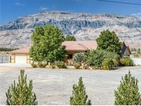 Charming single-story home features well-kept landscaping and a spacious gravel yard with mountain views at 5090 N David St, Pahrump, NV 89060